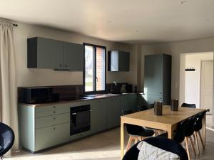 eine Küche mit einem Holztisch und einem Tisch und Stühlen in der Unterkunft Les Gîtes du Colombier in Ollé + 20 Fotos