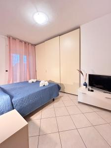 a bedroom with a bed and a flat screen tv at Galliano Flexrent - Immobiliare Abissinia in Riccione