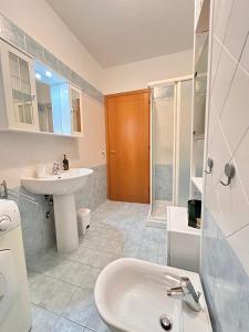 a white bathroom with a sink and a toilet at Galliano Flexrent - Immobiliare Abissinia in Riccione +13 photos