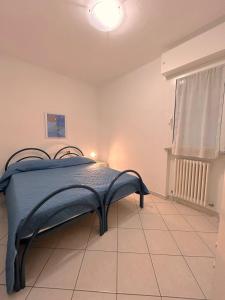 a bedroom with a bed with a blue blanket on it at Galliano Flexrent - Immobiliare Abissinia in Riccione