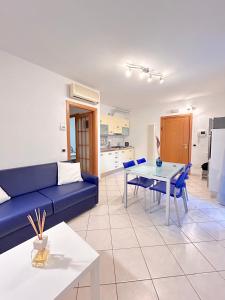 a living room with a blue couch and a table at Galliano Flexrent - Immobiliare Abissinia in Riccione