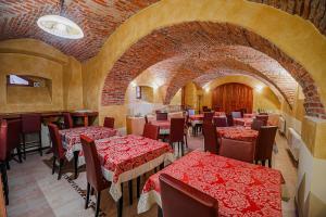 a restaurant with red tables and chairs and a brick wall at Bed & Breakfast Šilak in Ptuj