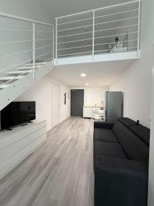 a living room with a black couch and a staircase at Viva Residence in Calderara di Reno