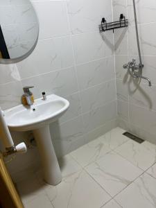 Khando's Resort في Passanauri: حمام أبيض مع حوض ودش