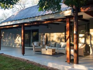a wooden pavilion with couches and a table at Nzenga Lodge in Hoedspruit