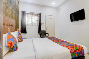 オールド･ゴアにあるFabHotel Golden Nest Deluxe - Nr Calangute Beachのベッドとテレビがあるホテルの部屋