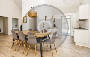 een keuken en eetkamer met een houten tafel en stoelen bij Amazing Home In Haderslev in Diernæs
