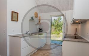 een keuken met witte kasten en een glazen wand bij Amazing Home In Haderslev in Diernæs