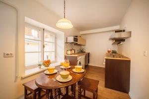 a kitchen with a wooden table with chairs and a dining room at Old Town Luxury 2 Bedroom Suite 65 m2 on 3rd floor in Tallinn