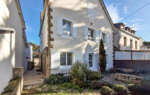 ein weißes Haus mit weißen Fenstern und einer Veranda in der Unterkunft One Bedroom Awesome Apartment In Carnac in Carnac-Plage + 6 Fotos