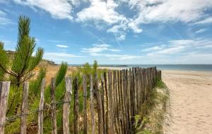 einen Zaun an einem Strand mit dem Ozean im Hintergrund in der Unterkunft One Bedroom Awesome Apartment In Carnac in Carnac-Plage