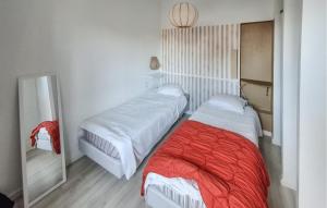 ein Schlafzimmer mit zwei Betten und einem Spiegel in der Unterkunft One Bedroom Awesome Apartment In Carnac in Carnac-Plage