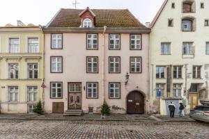 a pink house in the middle of two buildings at Old Town Luxury 2 Bedroom Suite 65 m2 on 3rd floor in Tallinn