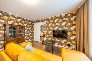 a living room with a yellow couch and a television at Old Town Luxury 2 Bedroom Suite 65 m2 on 3rd floor in Tallinn