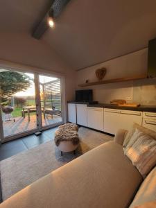a living room with a couch and a large window at Out & LODGE Les Spirous in Les Géronsarts