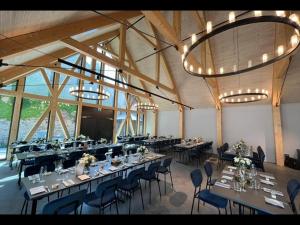 a large banquet hall with long tables and chairs at Das Hotel by Ferber in Monheim