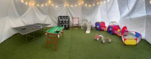 una tenda bianca con un'area giochi con un tavolo e un ping-pong di Awaji Play Resort a Minamiawaji