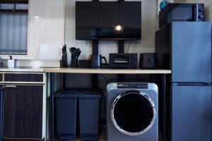 a kitchen with a washing machine under a counter at NEW OPEN ! Central Kobe 最大9名 三宮,元町,中華街,北野へアクセス抜群 アメニティ,長期宿泊設備充実 in Kobe