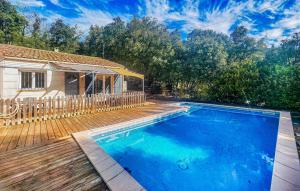 a swimming pool with a wooden deck and a house at Pause Nature Avec Piscine in Ferrières-Poussarou +13 photos