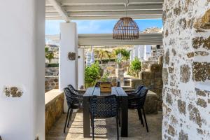 a table and chairs on a patio with a view at Aurora Mykonos Villas in Kalafatis