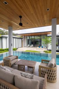 an outdoor living room with a pool and a house at Botanica Foresta B10 in Phuket