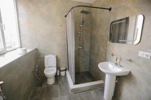 a bathroom with a shower and a toilet and a sink at Hotel Caucasus in Tbilisi City