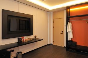 a room with a flat screen tv and a hallway at H-Dragon Hotel in Ðông Thôn +2 photos