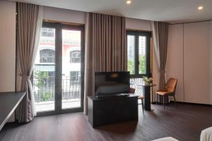 a hotel room with a couch and a balcony at H-Dragon Hotel in Ðông Thôn