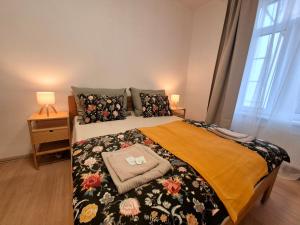 a bedroom with a bed with a floral bedspread at City Center Apartments - Měšťanský dům Minoritská II in Brno