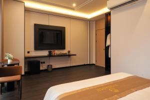 a hotel room with a bed and a flat screen tv at H-Dragon Hotel in Ðông Thôn