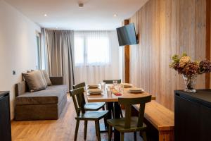 ein Wohnzimmer mit einem Tisch und einem Sofa in der Unterkunft Le Sort Mountain Retreat in Passo del Tonale