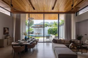 a living room with a couch and a table with chairs at Botanica Foresta B10 in Phuket