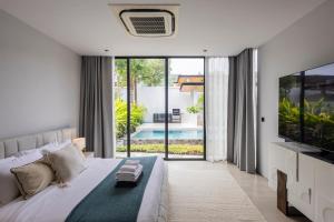 a bedroom with a large bed and a large tv at Botanica Foresta B10 in Phuket +63 photos