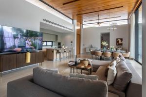 a living room with a couch and a dining room at Botanica Foresta B10 in Phuket