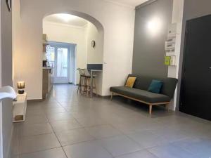 a living room with a couch on a tile floor at ღ Calysta - Studio Proche Centre Ville & Gare in Douai