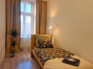 a bedroom with a bed with a pillow and a window at City Center Apartments - Měšťanský dům Minoritská II in Brno