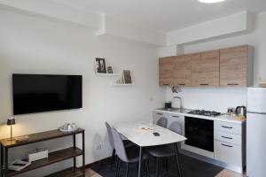 a small kitchen with a table and a tv on the wall at Casa Laura - Home and Relax Malpensa in Lonate Pozzolo