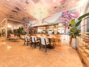 ein Restaurant mit einem Speisesaal mit Tisch und Stühlen in der Unterkunft Mercure Xian City Centre in Xi'an