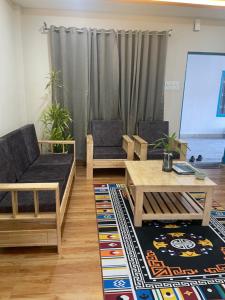 a living room with two chairs and a table at Karma Stay 2BHK apartments in Jaigaon