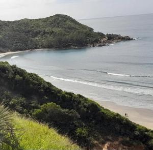 Una vista de una playa con gente en el agua. en Kitnet Praia do Porto, en Imbituba