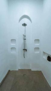 a white room with an umbrella on a wall at Chic 2BR Villa w/Rock Plunge Pool in Denpasar