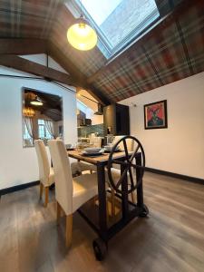 a dining room with a table and chairs and a skylight at Balmoral Lodge, King Size Apartment by The Hive WA1 in Warrington