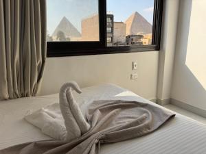 a bed with a towel on it in front of a window at Prince Pyramids Hotell in Cairo