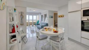 a kitchen and living room with a white table and chairs at Ocean View! 2-Bedroom Cosy Condo in Portimão