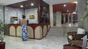 a woman standing at a counter in a lobby at Ocean View! 2-Bedroom Cosy Condo in Portimão +6 photos