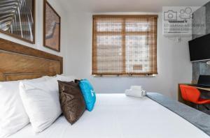 ein Schlafzimmer mit einem großen weißen Bett und Kissen in der Unterkunft Studio Centro - 7 Copas in Rio de Janeiro