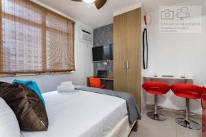ein Schlafzimmer mit einem Bett und zwei roten Stühlen in der Unterkunft Studio Centro - 7 Copas in Rio de Janeiro