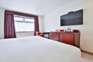 a hotel room with a bed and a flat screen tv at Copthorne Hotel Cardiff-Caerdydd in Cardiff +22 photos