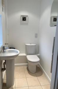 een witte badkamer met een toilet en een wastafel bij Kingsbarns Apartment in Kingsbarns +11 foto's