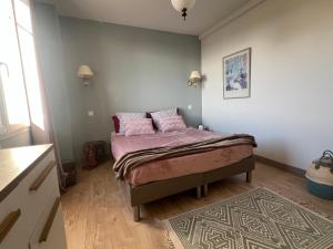 a bedroom with a bed with pink pillows on it at Golden hours luxury and panoramic view in Nice